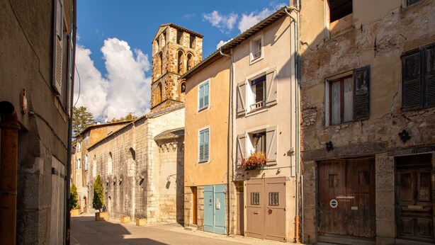 A narrow street with historic buildings, a church tower, and a sign indicating a parking area. - Apartment '1st Floor' with Wi-Fi (Castellane)