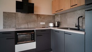 Una cocina moderna con horno empotrado, cafetera y grifo negro.
