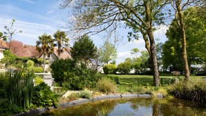 A pond with water plants, surrounded by various trees and shrubs. - La Clef des Champs - Pool and Jacuzzi - Lémeré (Lémeré)