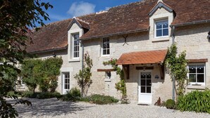 A stone building with a tiled roof, a central entrance with a door, and a small porch. - La Clef des Champs - Pool and Jacuzzi - Lémeré (Lémeré)