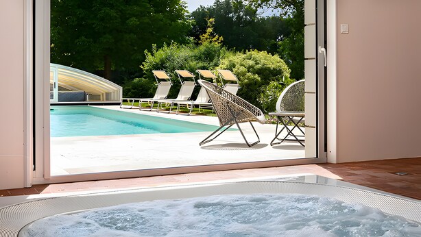 A poolside area with a hot tub, lounge chairs, and a view of a swimming pool. - La Clef des Champs - Pool and Jacuzzi - Lémeré (Lémeré)
