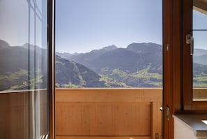 Un balcon en bois offrant une vue sur les montagnes.