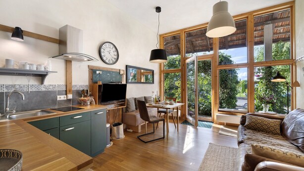 Una cocina moderna con comedor, ventanas amplias y un rincón de descanso acogedor.