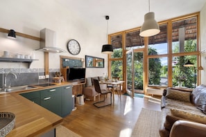 Una cocina moderna con comedor, ventanas amplias y un rincón de descanso acogedor.