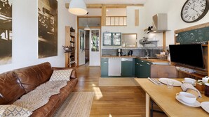 Una cocina moderna con comedor, un sofá y un reloj grande en la pared.