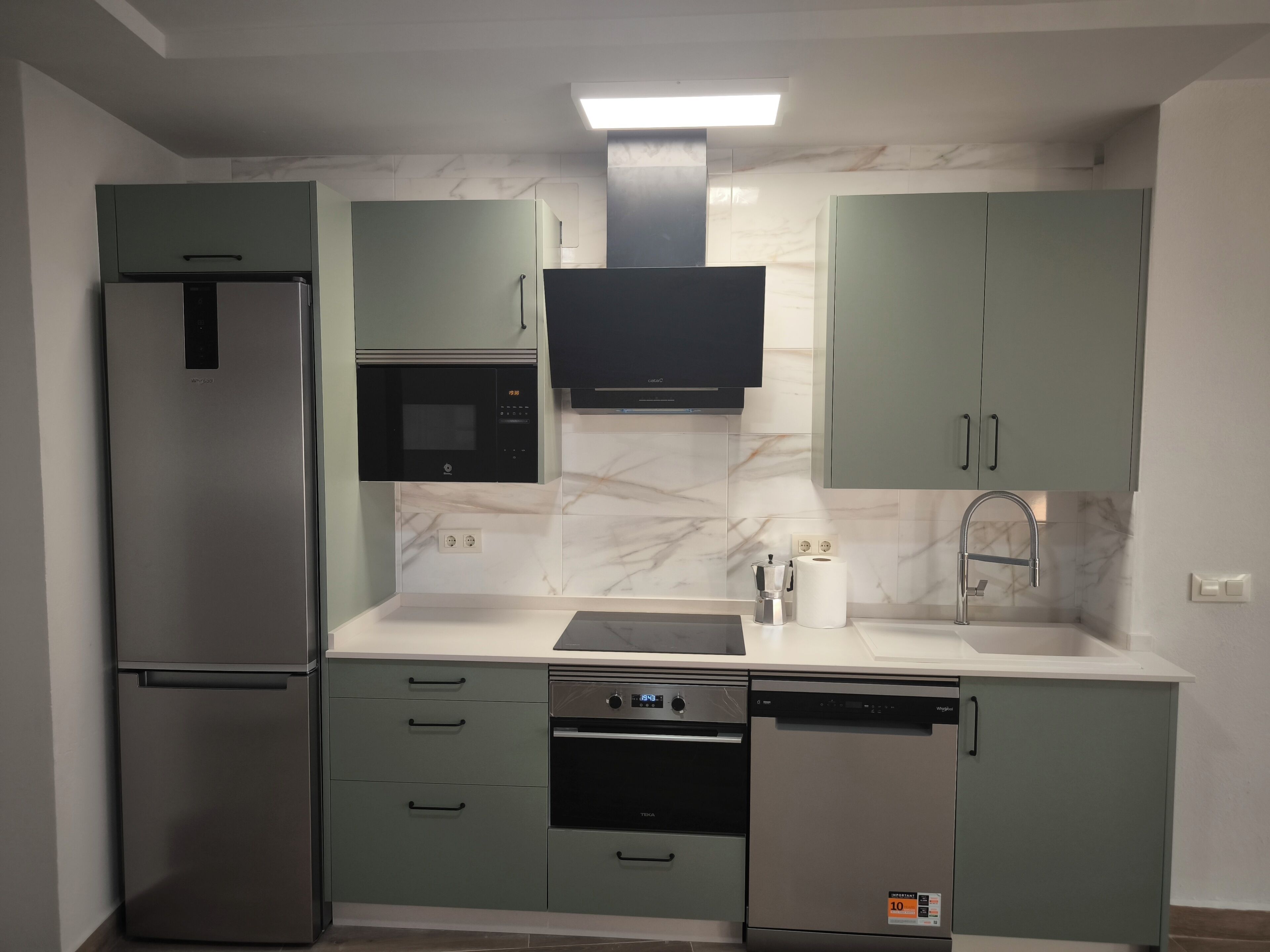 Een microgolfoven, een oven, een kookplaat, een vaatwasser