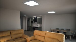 A modern living room with two sofas and a coffee table, a dining area with a table and chairs, and a kitchen in the background. - Ideal for Families (Alájar)