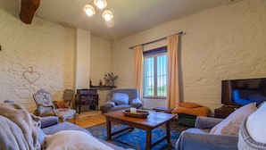 A cozy living room with a fireplace, a television, and comfortable seating.