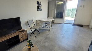 Un salon avec un téléviseur, un bureau et une chaise.