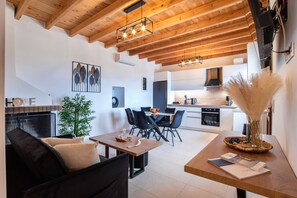 Una sala de estar moderna con chimenea, comedor y cocina.