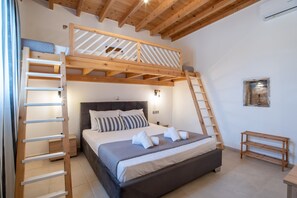 Une chambre avec un lit superposé, une échelle en bois, une table de chevet et une étagère fixée au mur.