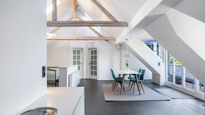Ein modernes Interieur mit Essbereich, Küche und Blick durch große Fenster.