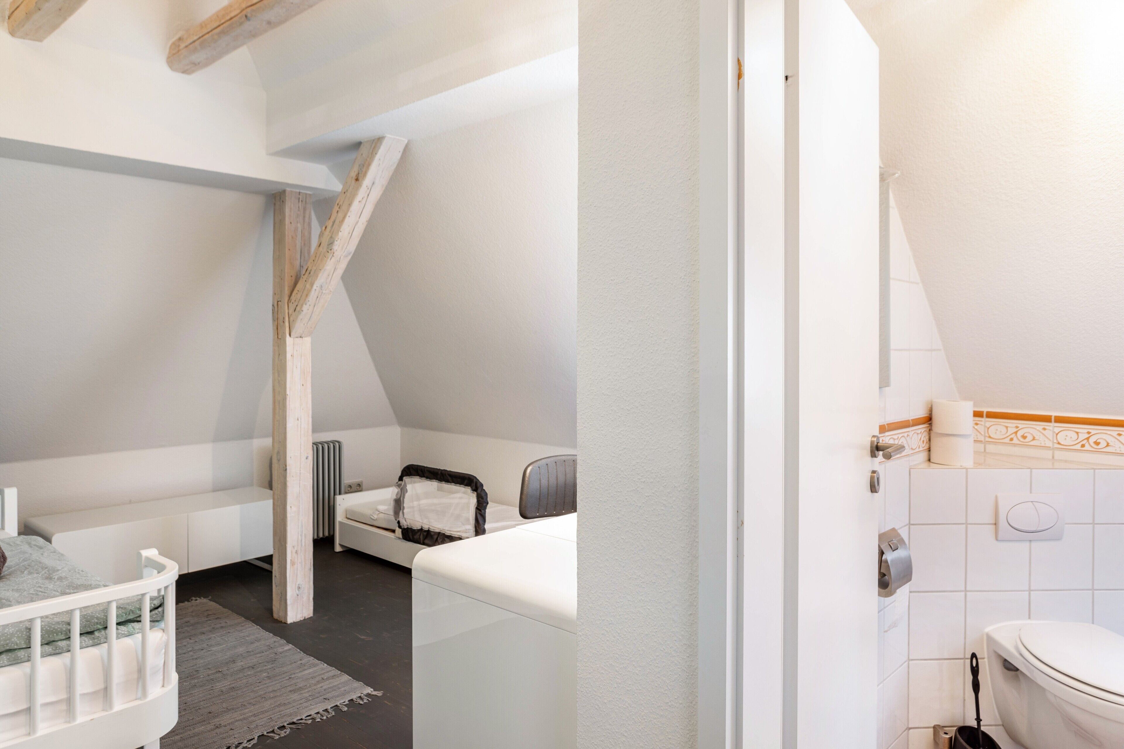 Ein Schlafzimmer mit Etagenbett, kleinem Schreibtisch und Heizkörper.