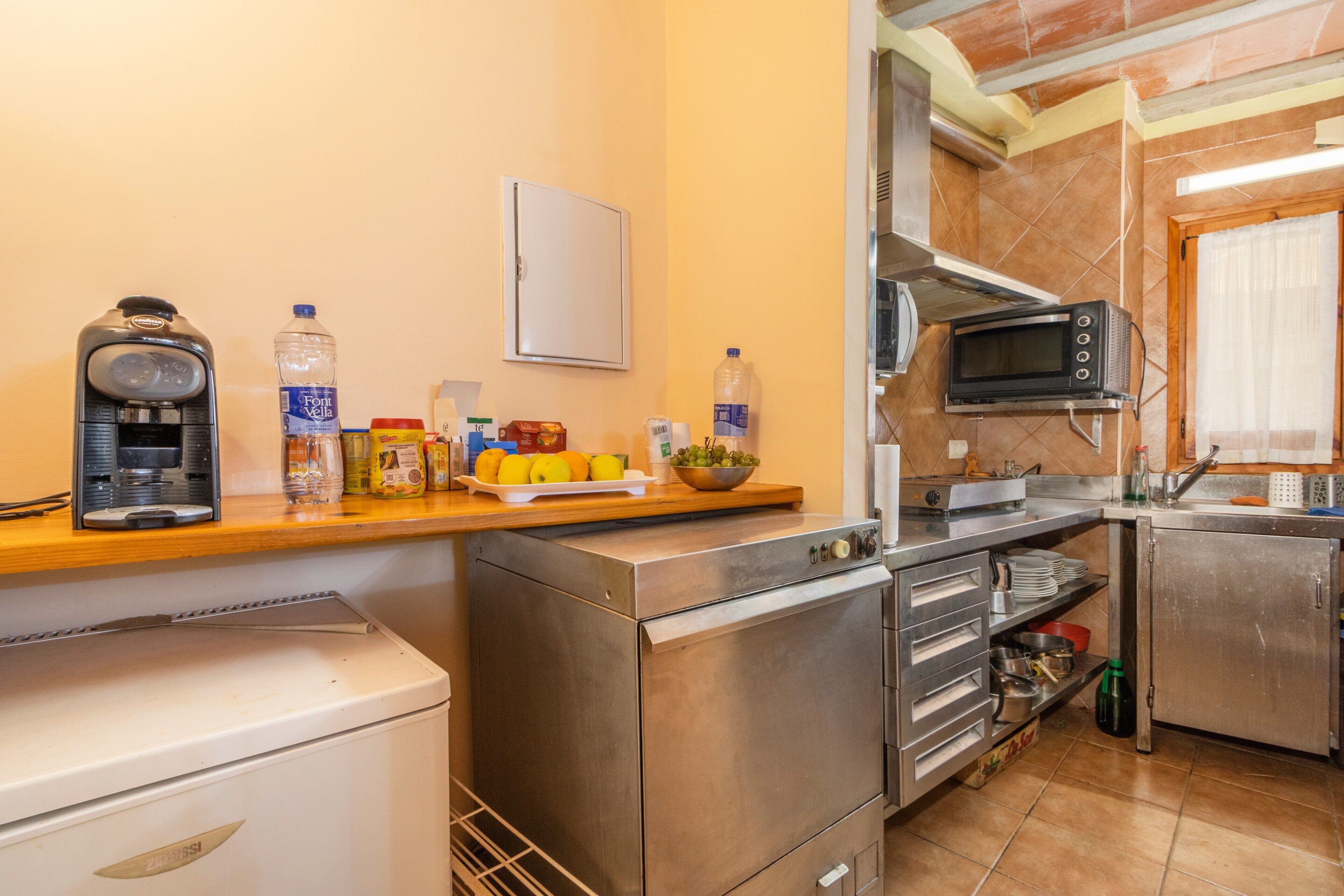 A kitchen with a microwave, oven, and coffee maker.