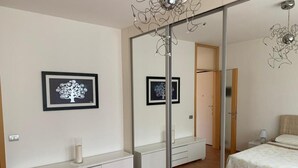 A bedroom with a bed, a bedside table, a mirror, and two framed pictures on the wall. - Apartment 'Lampone' with Mountain View, Private Terrace and Wi-Fi (Cantello)