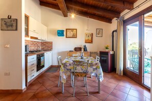 A kitchen with a dining table, chairs, a refrigerator, and a stove.