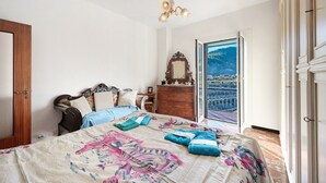 Een slaapkamer met een bed, een kaptafel en uitzicht op een balkon.