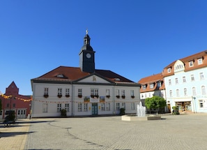 Ein historisches Gebäude mit einem Glockenturm, einem Innenhof und einer Fontäne.