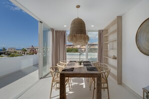 Et spiseområde med et bord, stole og en hængende lampe.