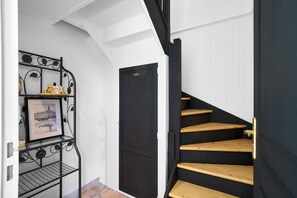 A staircase with wooden steps and a black door.