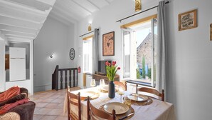 Ein Essbereich mit einem Tisch für vier Personen, einer Blumenvase und Blick ins Freie.
