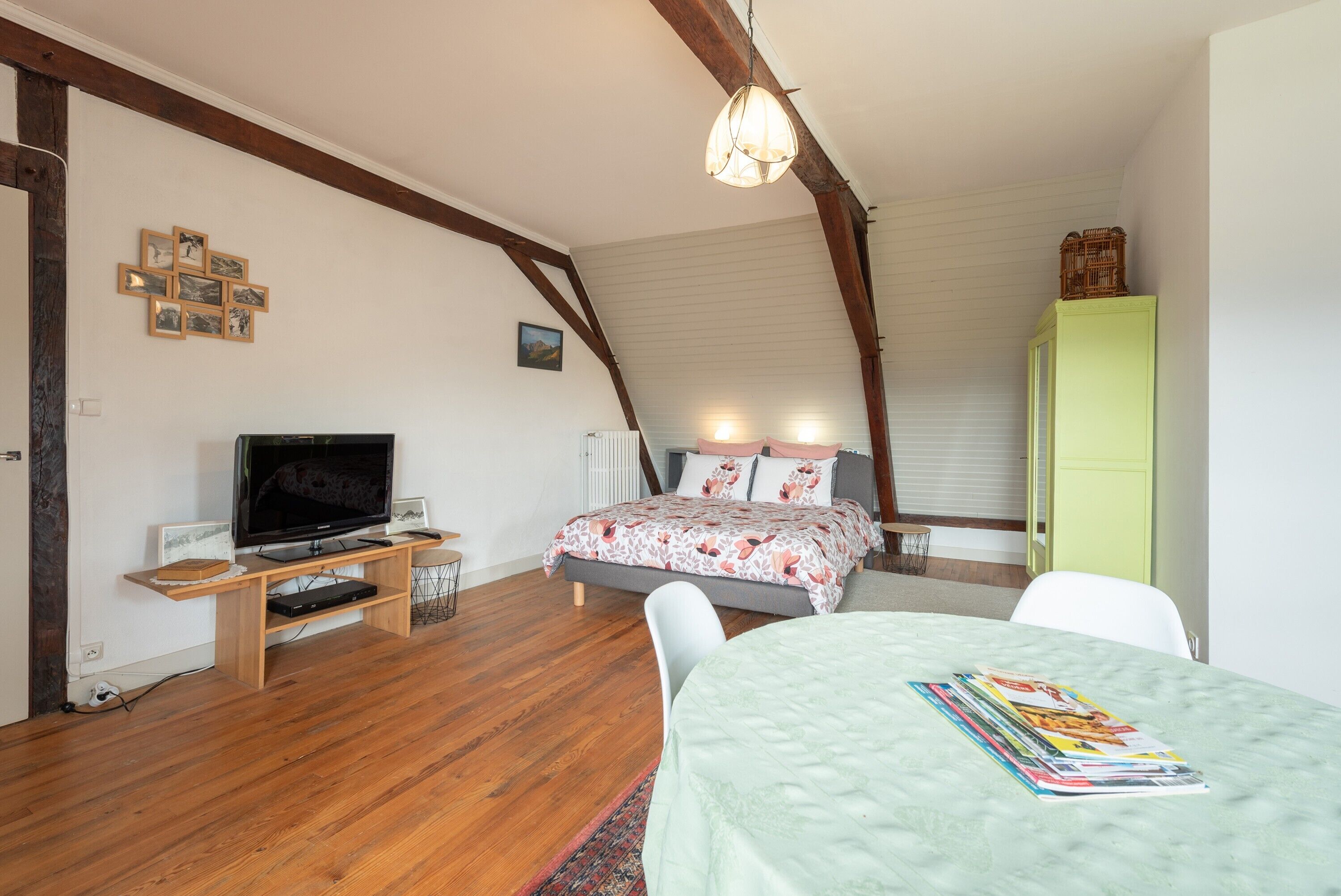 A bedroom with a bed, a TV, a desk, and a chair.