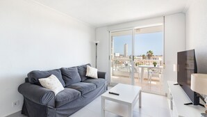 A modern living room with a grey sofa, a white coffee table, and a TV. - Apartment 'Bahía Mar' with Sea View, Private Terrace and Wi-Fi (Puerto de Mazarrón)
