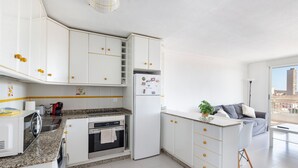 A modern kitchen with white cabinets, granite countertops, and a built-in oven. - Apartment 'Bahía Mar' with Sea View, Private Terrace and Wi-Fi (Puerto de Mazarrón)