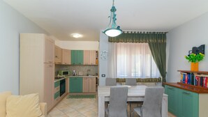 A compact living space with a kitchenette, dining area, and a sofa.