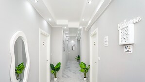 A hallway with a white mirror, potted plants, a welcome sign, and a sign indicating a VIP area. - Room 'Dolce Relax - Classic' with Balcony, Wi-Fi and Air Conditioning (Catania)