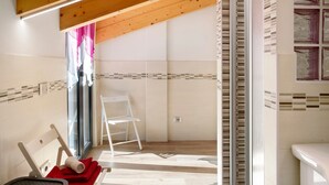A room with a wooden ceiling, a white chair, a red towel, and a glass door leading outside. - Holiday Home 'Sam Fiamet' with Mountain View, Shared Garden and Wi-Fi (GROSIO)
