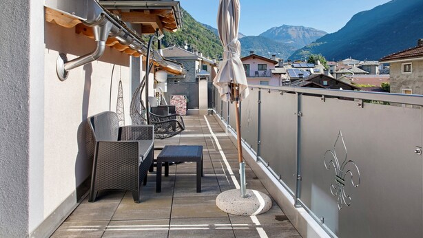 A balcony with outdoor furniture, a pergola, and a view of a mountainous landscape. - Holiday Home 'Sam Fiamet' with Mountain View, Shared Garden and Wi-Fi (GROSIO)