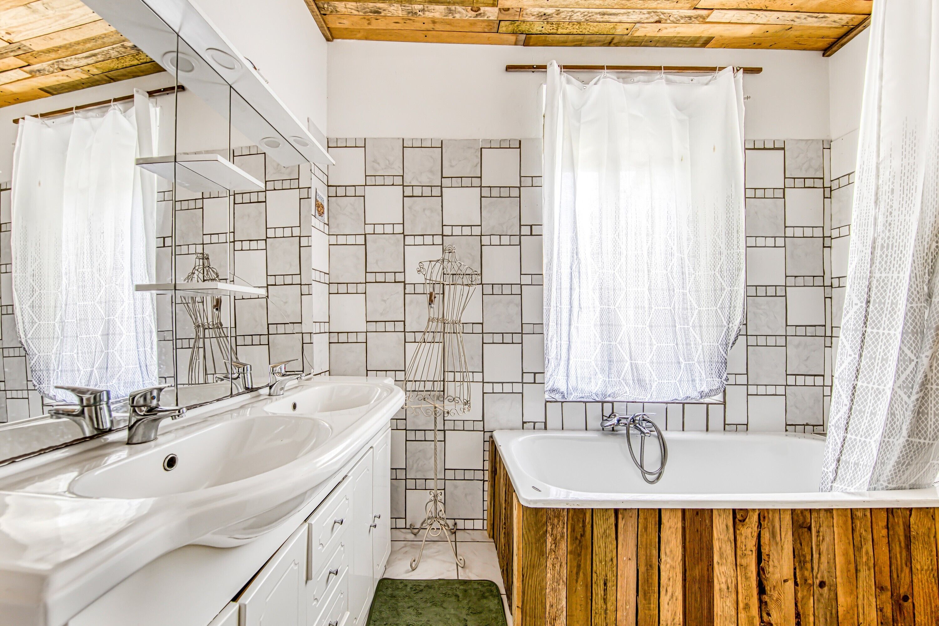 A bathroom with two sinks, a bathtub, and a shower curtain.