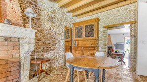 A rustic interior with a stone wall, wooden furniture, and a tiled floor.