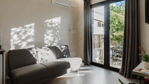 Ein modernes Wohnzimmer mit einer Couch, einem Tisch und Blick ins Freie.