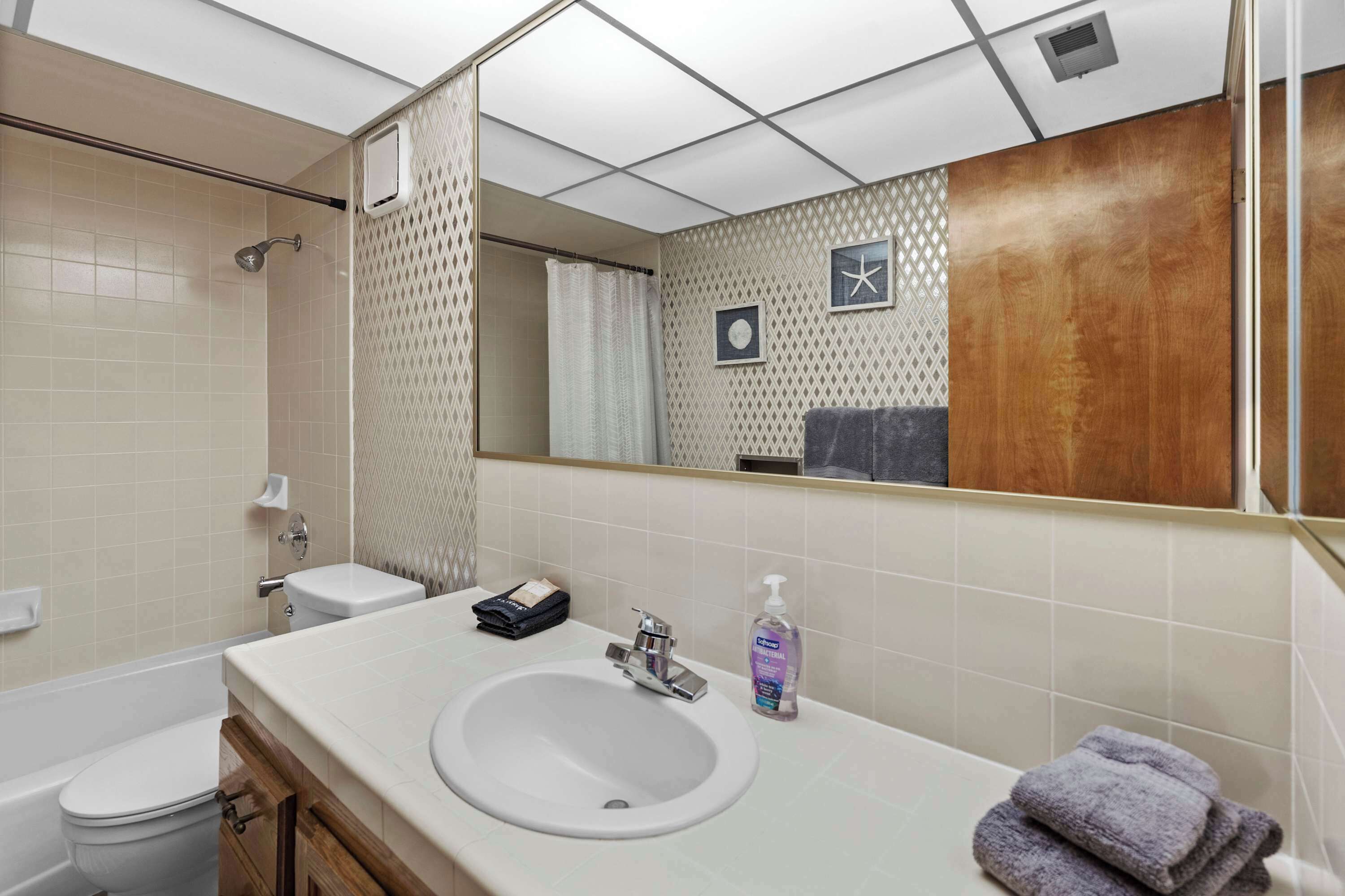 Ein Badezimmer mit Waschbecken, Spiegel, Toilette und Dusche.