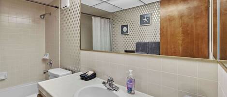 Ein Badezimmer mit Waschbecken, Spiegel, Toilette und Dusche.