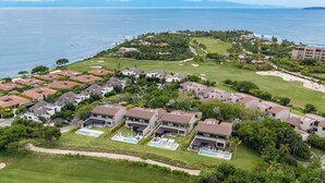 An aerial view of a coastal residential area with houses, a golf course, and a large body of water. - Golf-View Luxury Villa with Pool, Chef Service and Premier Golf in Punta Mita (Nayarit)