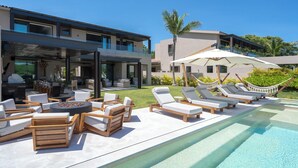 A poolside area with lounge chairs, a fire pit, and a covered seating area. - Golf-View Luxury Villa with Pool, Chef Service and Premier Golf in Punta Mita (Nayarit)