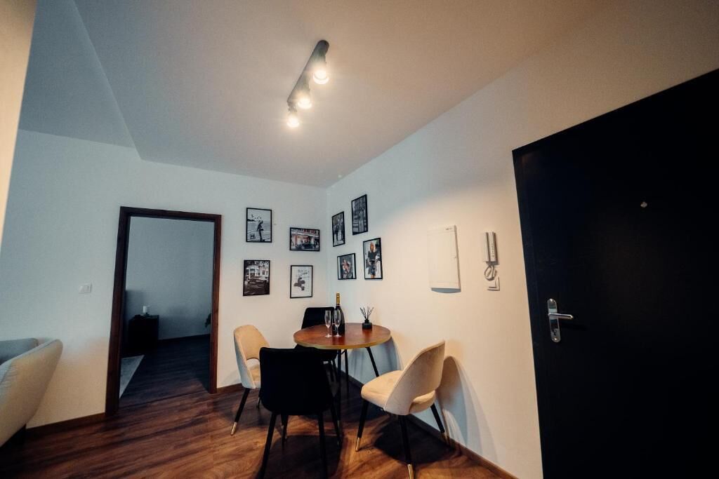 Un coin repas avec une table en bois, quatre chaises et des tableaux encadrés accrochés au mur.