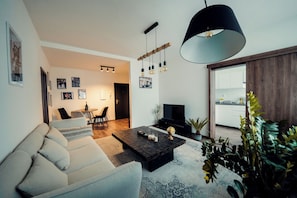 Una sala de estar moderna con un sofá, una mesa de centro y una lámpara colgante.