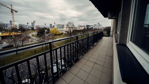Een balkon met uitzicht op een bouwplaats en stadsbeeld.