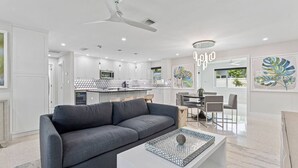 Una sala de estar moderna con un sofá gris, una mesa de centro y un comedor con sillas y una mesa.