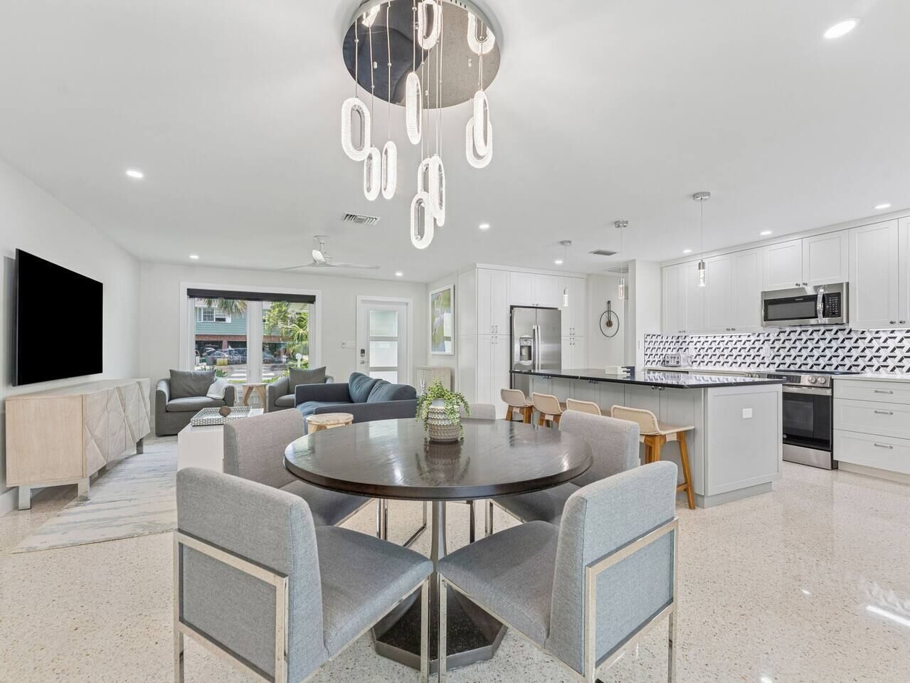 A modern kitchen with white cabinets, a black countertop, and a built-in microwave.