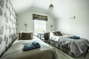 A room with two beds, a table, and a chair. - Villa Wolax (Kaarina)