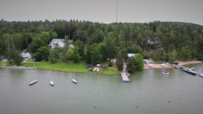 A lakeside property with a dock, boats, and a small building with a red roof. - Villa Wolax (Kaarina)