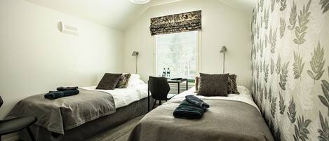 A room with two beds, a desk, and a chair.