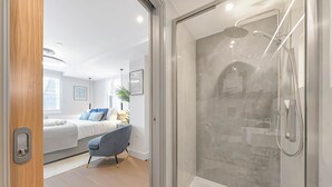 A modern bathroom with a glass-enclosed shower, a bathtub, and a toilet. - Studio 5 @ OneStay Maida Vale (London)