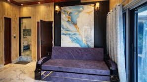 Een modern interieur met een paarse bank, een marmeren wand en een houten plafond.