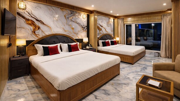 Une chambre d’hôtel avec deux lits, un sol en marbre, des boiseries et un grand miroir.